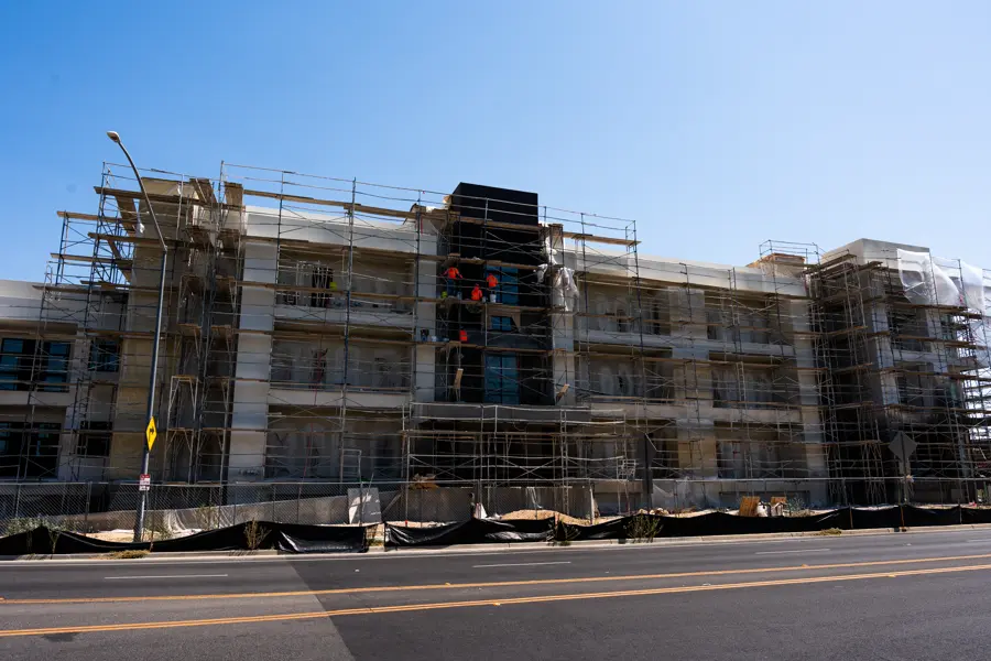 Mid-rise Audubon building elevation wrapped in scaffolding during exterior painting