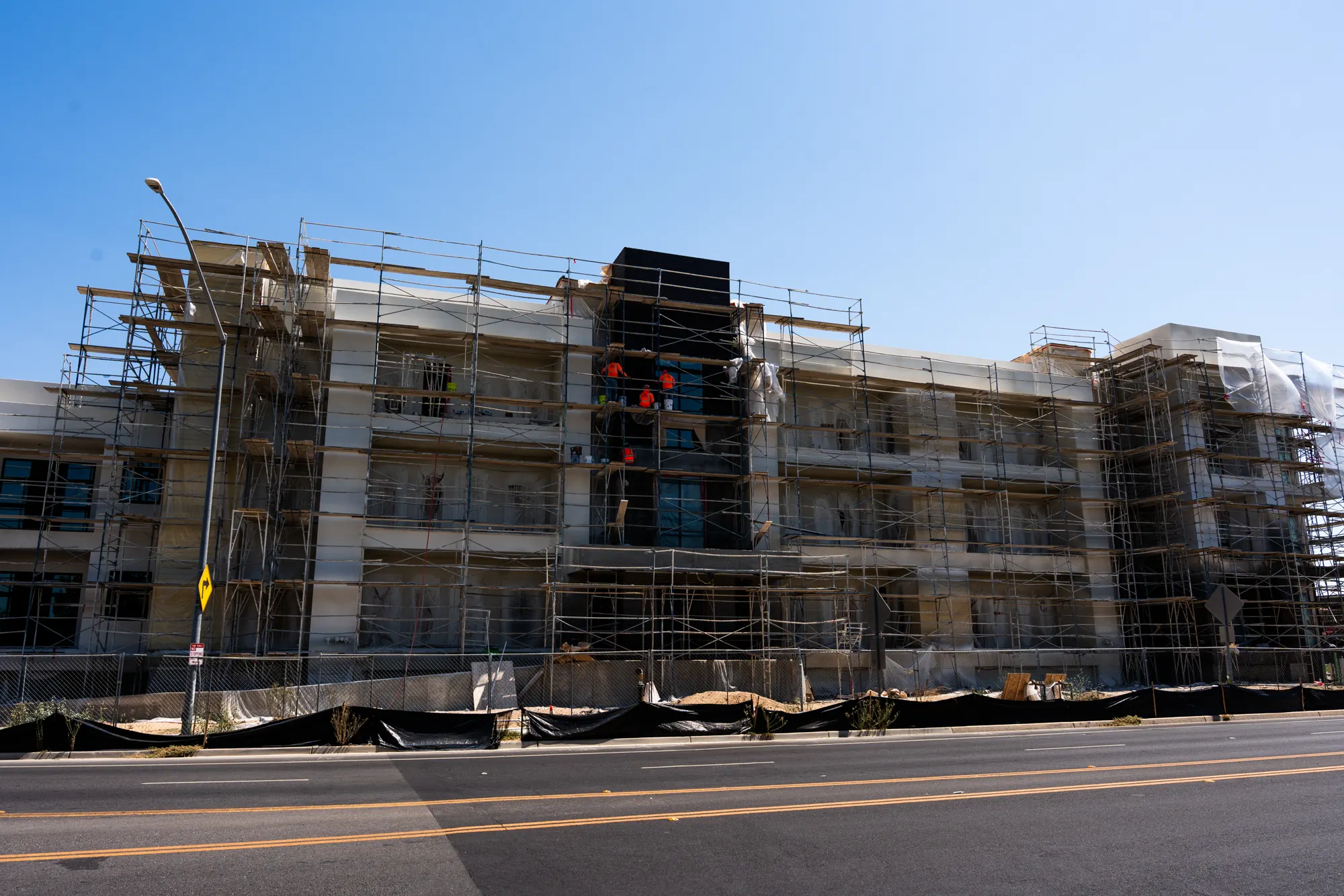 Mid-rise Audubon building elevation wrapped in scaffolding during exterior painting