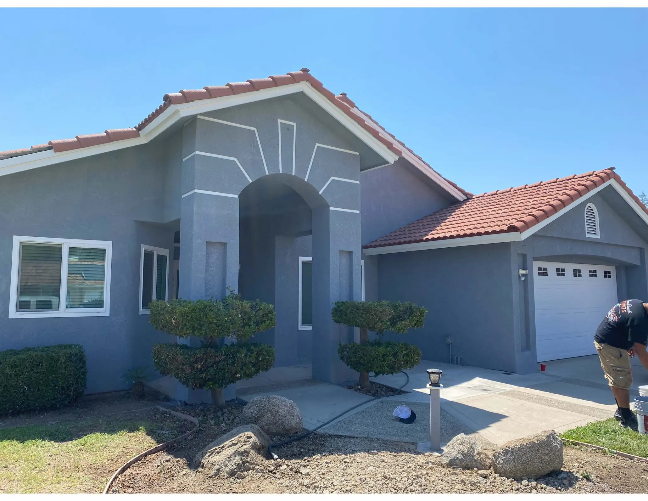 Single-story stucco home repainted in gray with white trim detail