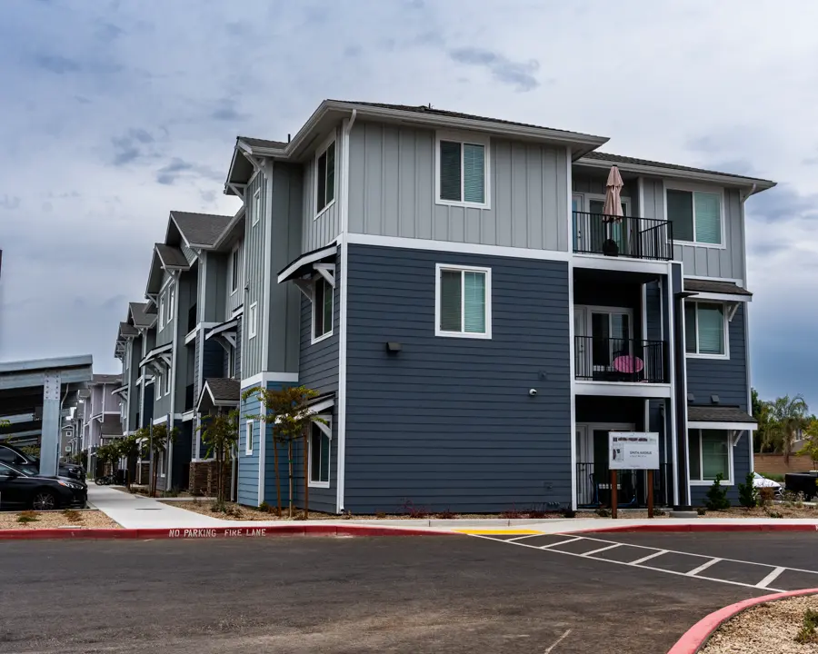 Three-story apartment building at 695 D Street painted slate gray with white trim