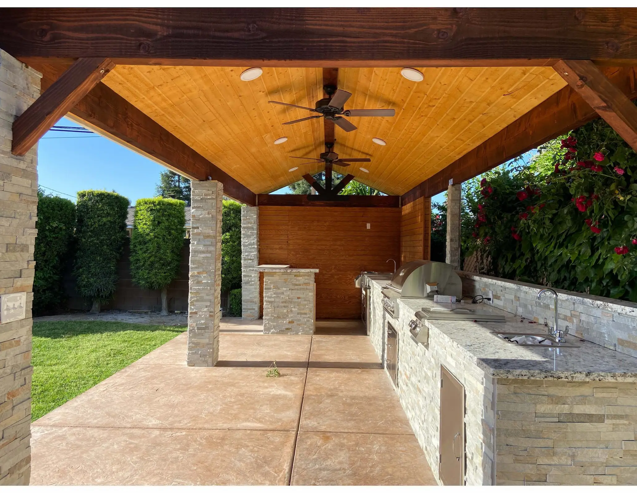 Covered patio with stained timber ceiling and built-in outdoor kitchen