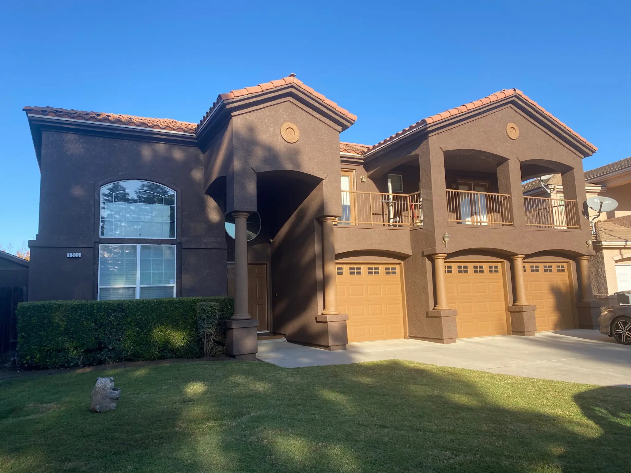 Two-story stucco home with warm brown exterior paint