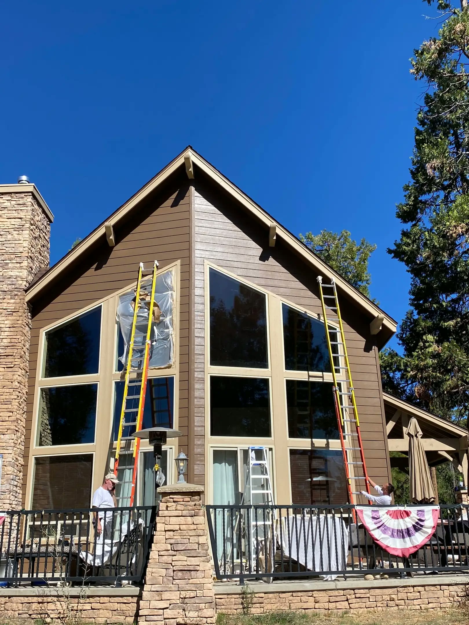 Painter rolling fresh paint onto the stucco exterior of a Fresno home